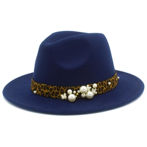 Détail d'un chapeau en laine bleu marine avec ruban léopard, perles et motifs floraux
