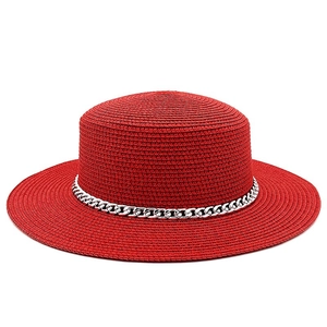 Detailed macro view of the finely woven red straw material and silver chain decor