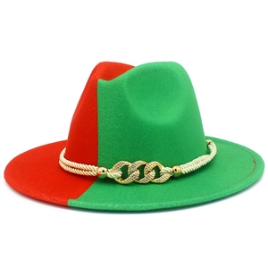 Détail d'un chapeau fedora rouge et vert avec corde blanche et boucle en métal doré