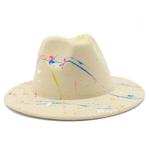 Detailed texture of beige fedora hat with artistic multi-color ink splatter design