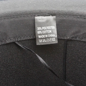 Close-up of washing label showing 35% polyester and 65% cotton blend on black fedora hat