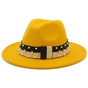 Dettaglio di un cappello fedora in lana gialla con fascia decorata con perle e strass