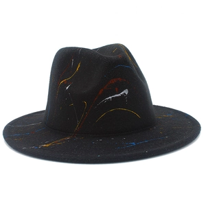 Close-up of artistic red yellow blue splatter paint on a black wool jazz fedora hat