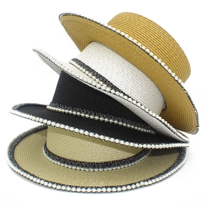 Detail of four colorful straw hats with elegant pearl trim in French style design