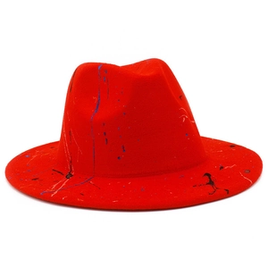 Detail of red fedora hat with blue and black artistic paint splash and wide brim