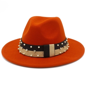 Dettaglio cappello fedora in lana arancione con fascia decorativa di perle e strass