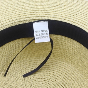 Detailed close-up of straw sun hat interior with sweatband and care label
