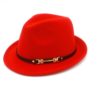 Dettaglio cappello fedora in lana rossa con cinturino in pelle nera e fibbia dorata
