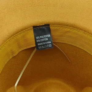 Detailed interior of yellow wool fedora hat showing 65% cotton blend label and sweatband