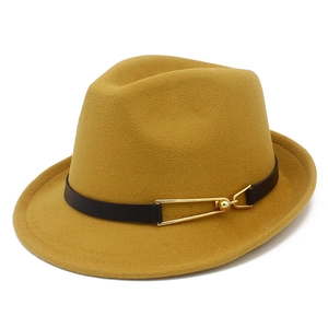 Close-up of mustard wool fedora with brown leather band and gold metal buckle detail