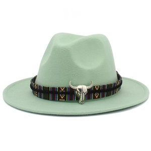 Vue détaillée du chapeau fedora vert menthe avec ruban ethnique et breloque tête de taureau