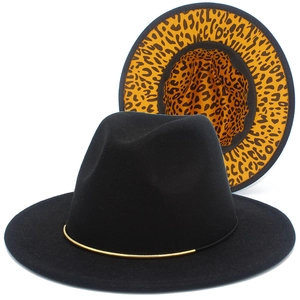 Dettaglio di cappello fedora nero con fodera leopardata gialla e nastro in metallo dorato