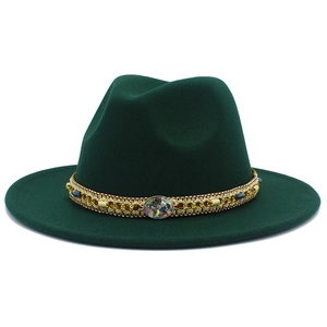 Détail du chapeau fedora en laine vert foncé avec ruban doré ethnique et perles colorées