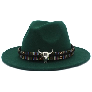 Détail du chapeau Fedora en laine vert foncé avec ruban ethnique et accessoire tête de taureau