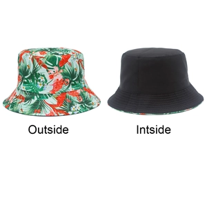 Detail showing the reversible bucket hat with tropical print and solid black canvas material