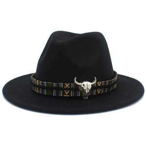 Détail d'un chapeau en laine noir avec ruban ethnique et pendentif crâne de taureau argenté