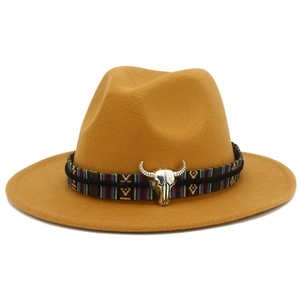 Détail d'un chapeau de cow-boy en laine jaune moutarde avec décoration tête de taureau