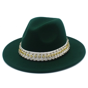 Détails d'un chapeau fedora vert foncé avec des rivets dorés et des strass jaunes