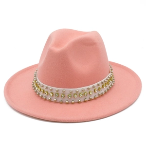 Détail du chapeau fedora rose en laine avec ceinture blanche, strass et rivets argentés