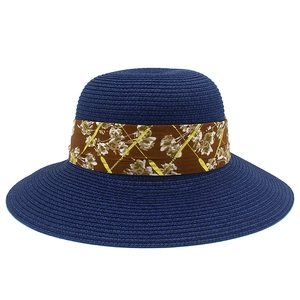 Detail of navy blue straw sun hat showing floral ribbon and fine weaving texture