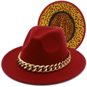 Detail of burgundy fedora with chunky gold chain and leopard print brim underside