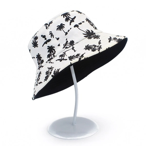 Reversible cotton bucket hat featuring a black coconut tree print on a white background