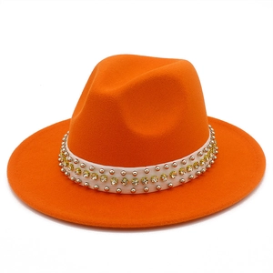 Détails de texture du chapeau fedora orange avec rivets argentés et strass jaunes