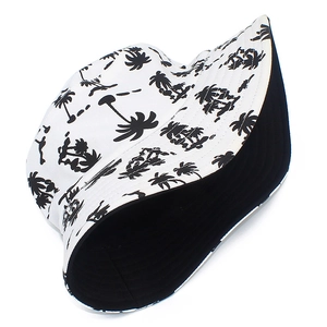 Reversible cotton bucket hat with tropical black palm tree print on white and plain black side