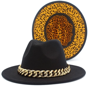 Detail of black fedora hat featuring a gold chain and leopard print lining detail