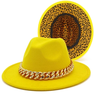 Detail of yellow wool fedora hat featuring a gold chain and leopard print lining