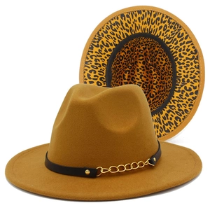 Detail of tan fedora hat featuring black leather band, gold chain and leopard lining