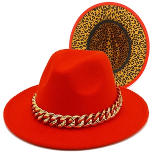 Detail of orange fedora wool hat featuring a thick gold chain and leopard print lining