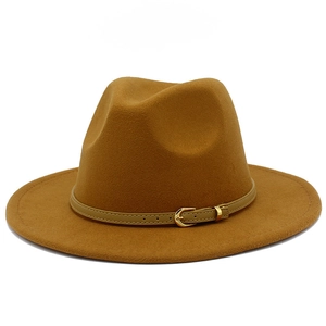 Detail of camel wool fedora hat featuring a slim brown leather band and gold metal buckle