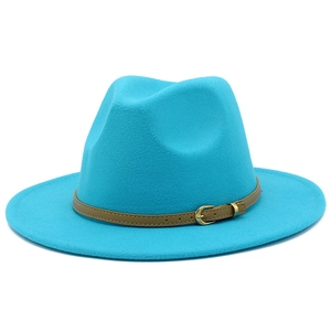 Detail view of a bright blue wool fedora hat with a brown leather buckle strap accent