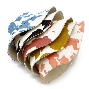 Detailed view of colorful cotton cow print bucket hats in blue black and yellow