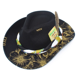 Detail of black wool fedora with gold floral print, bird feather and woven band accents