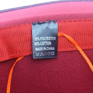 Detail of burgundy hat interior showing cotton blend label and fabric texture