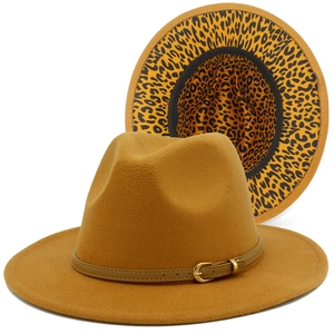 Detail of a camel fedora hat featuring a leopard print brim and leather strap with gold buckle