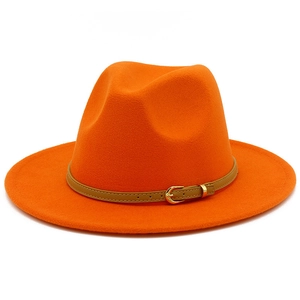 Close-up of bright orange wool fedora hat with brown leather band and gold buckle