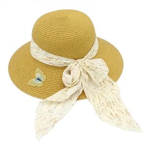 Detail of straw sun hat featuring floral chiffon ribbon bow and butterfly embroidery
