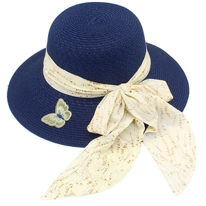 Detailed texture of dark blue straw sun hat with floral ribbon and butterfly patch decoration