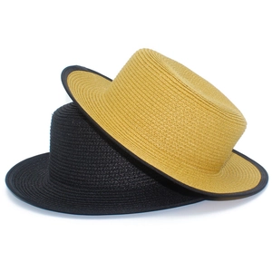 Détail de chapeaux de paille tressés en noir et gingembre avec texture fine