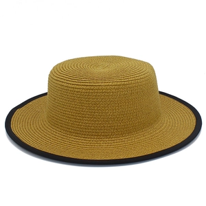 Détail du chapeau de paille canotier avec tissage serré et bordure noire contrastée