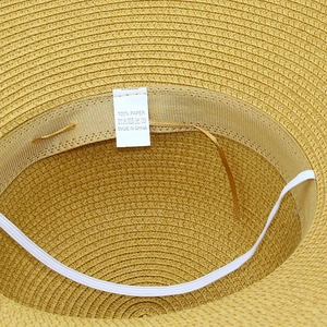 Detail of woven paper straw hat featuring inner sweatband, adjustment string, and label