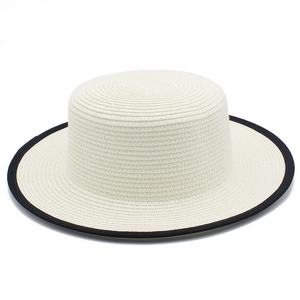 Détail du chapeau de paille blanc tressé avec bord noir contrasté et texture fine