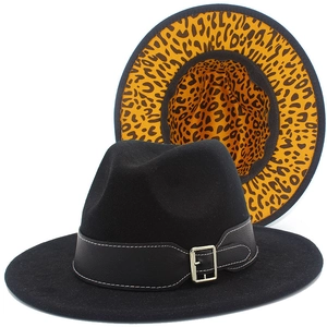 Detail of black fedora with silver buckle strap and yellow leopard print lining inside