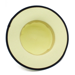 Détail du tissage fin en paille et du bord contrasté noir sur le chapeau de soleil