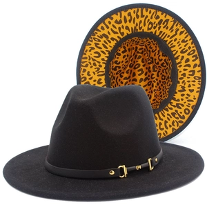Detail of classic black fedora hat with leopard print lining and golden metal buckle