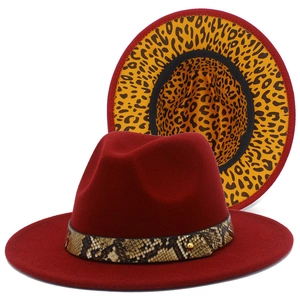 Detail of burgundy fedora hat with snakeskin band and yellow leopard print brim lining