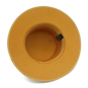 Detail view of the yellow fedora hat interior with sweatband and material care label